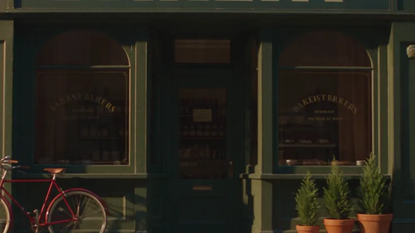 A crop of Seedance 2.5's first run: gold lettering painted on the bakery window that does not spell real words.
