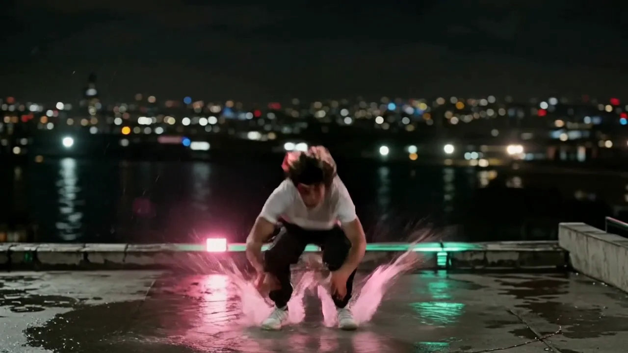 The rooftop backflip on Kling v3: a crouch, one tight rotation, both feet landing together into a deep squat with a splash, then a rise to standing