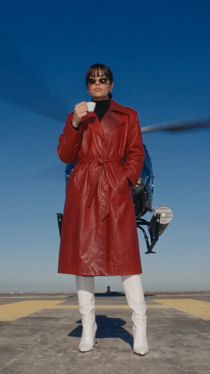 Juno on a rooftop helipad as a black helicopter lands behind her, lowering her sunglasses